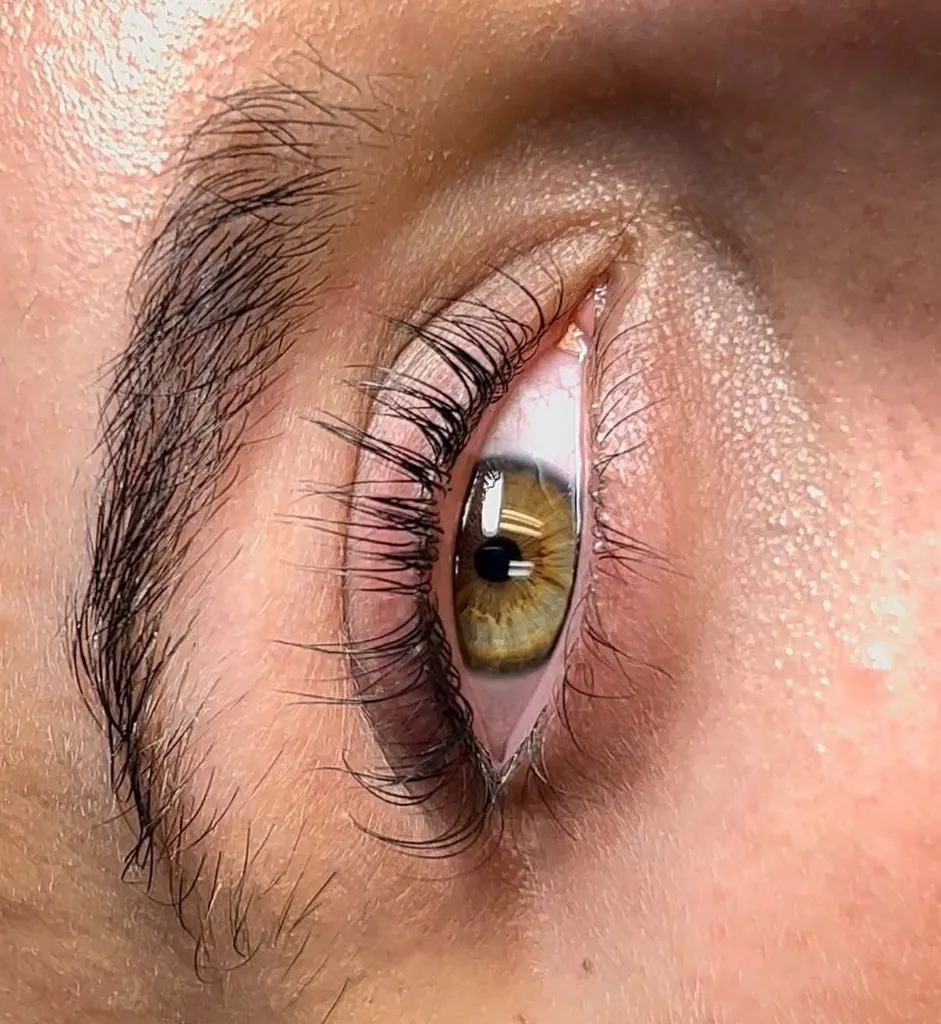 Close-up of a hazel eye with long, curled black eyelash extensions by Gigi’s Divine Artistry