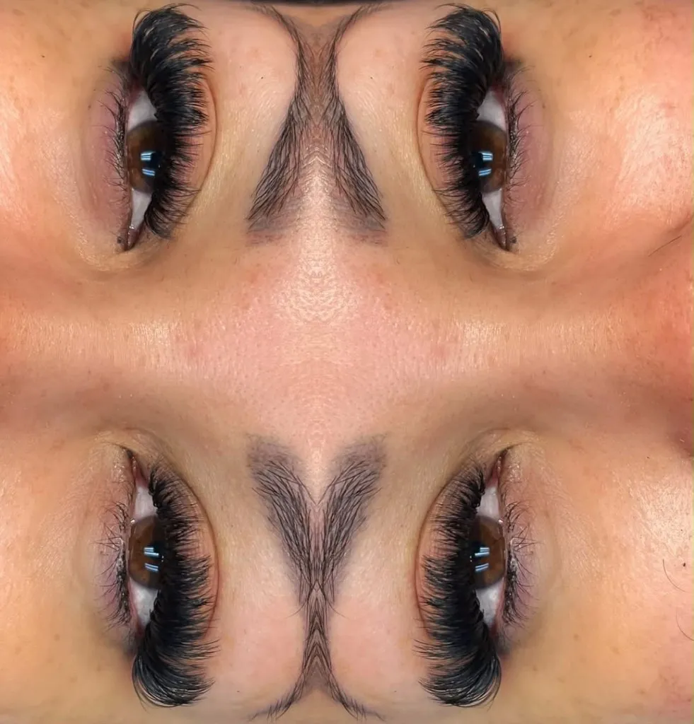 Mirrored close-up of dense volume eyelash extensions on a brown eye by Gigi’s Divine Artistry